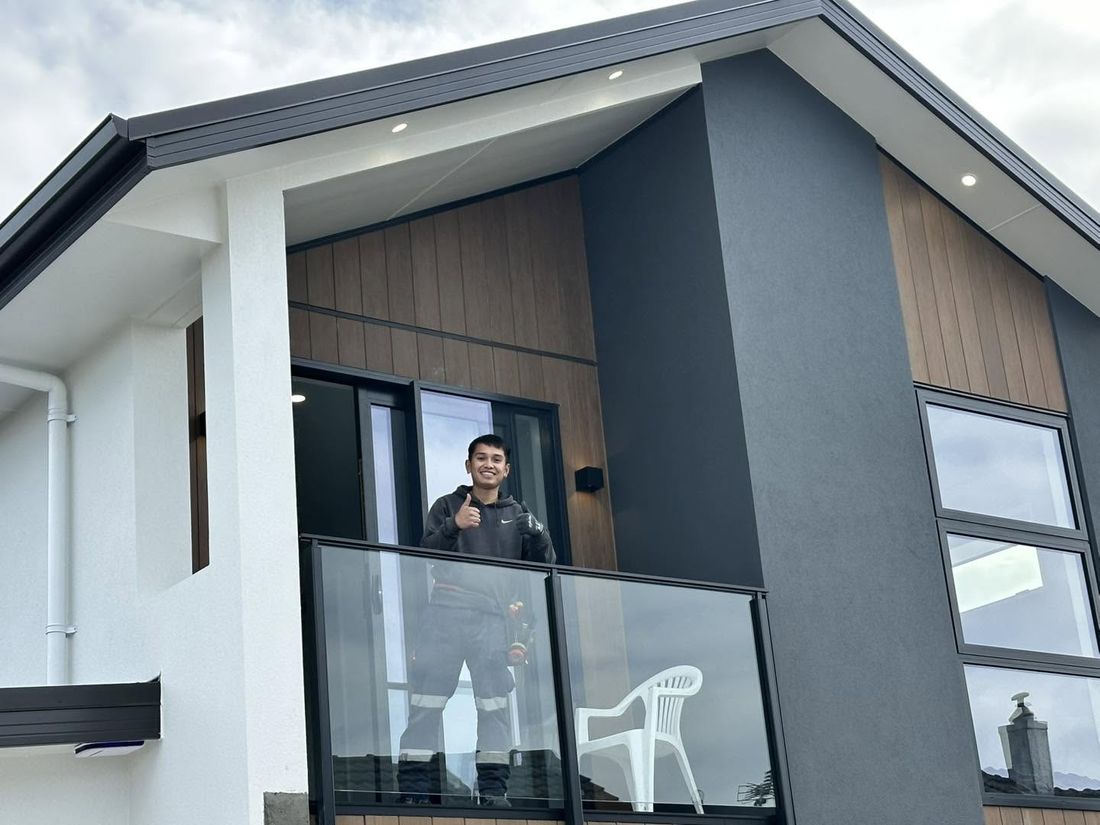 JIMED Electrical team member on the balcony of a modern new build with exterior wall lights